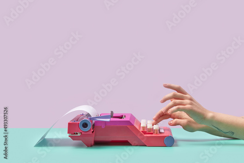 Girl writing on pink vintage typewriter photo