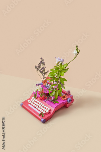 Vintage typewriter spitting out colorful spring flowers photo