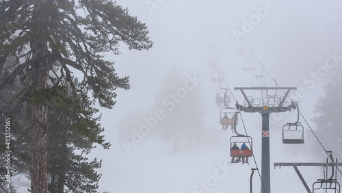 Ski lift in the fog, winter sports in bad weather. Mount Olympus ski resort, Cyprus photo