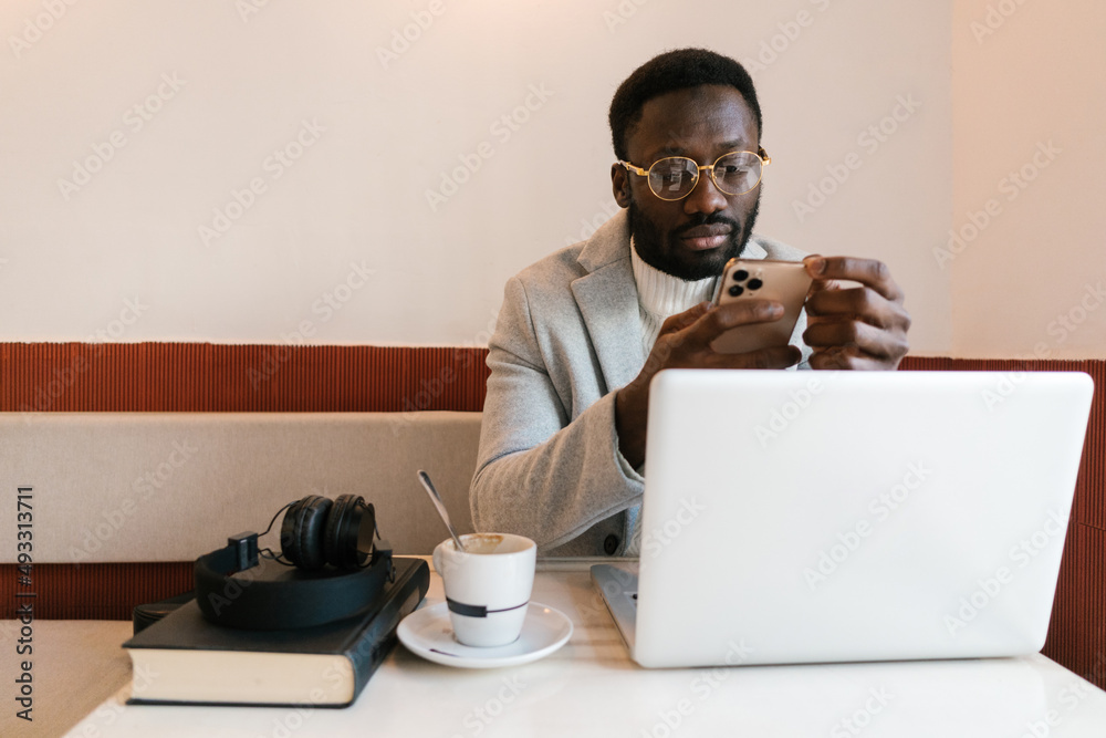 Black businessman working remotely in cafe Black businessman working remotely in cafe