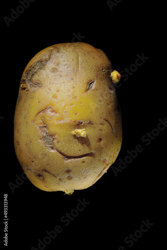 root potato on a black background. (looks like a face).