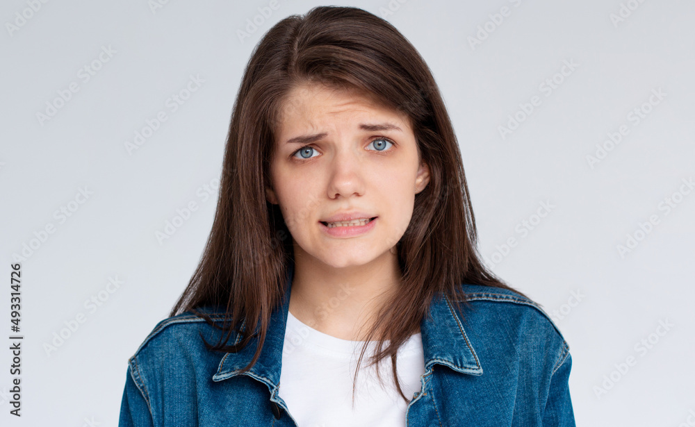 Close up portrait of confused caucasian woman looking on camera in puzzlement with facial expressions isolated over white background Close up portrait of confused caucasian woman looking on camera in puzzlement with facial expressions isolated over white background