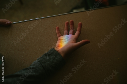 hand in rainbow light beam