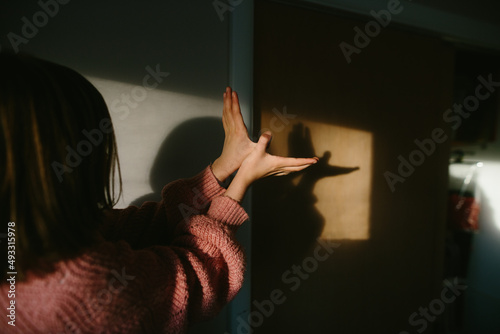 girl makes shadow puppet on wall  photo