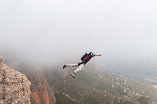Thrill-seeker BASE jumping taking off from summit