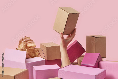 Woman holding brown cardboard box among colorful ones photo