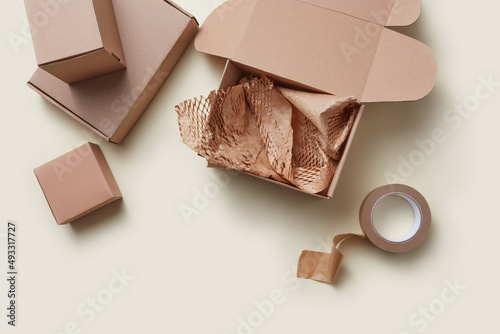 Boxes, craft paper and scotch on beige background photo
