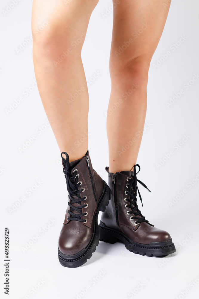 Women's brown spring boots made of genuine leather on a woman's leg. New collection of women's boots 2022 Women's brown spring boots made of genuine leather on a woman's leg. New collection of women's boots 2022