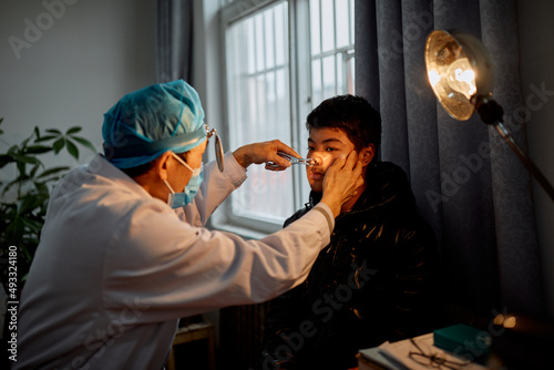 Doctor performing a test on a teenager at the hospital photo