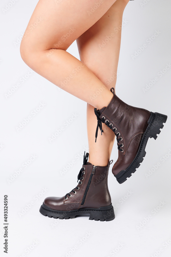 Women's brown spring boots made of genuine leather on a woman's leg. New collection of women's boots 2022 Women's brown spring boots made of genuine leather on a woman's leg. New collection of women's boots 2022
