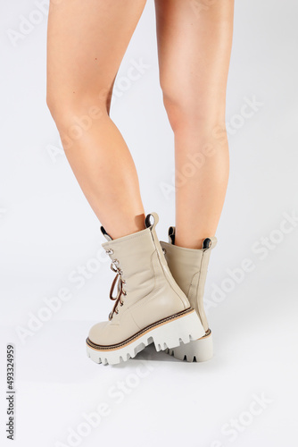 Women's white spring boots made of genuine leather are worn on a woman's leg. New collection of women's boots 2022