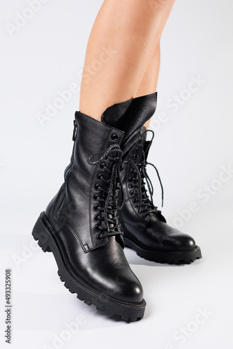 Women's black spring boots made of genuine leather are dressed on bare feet