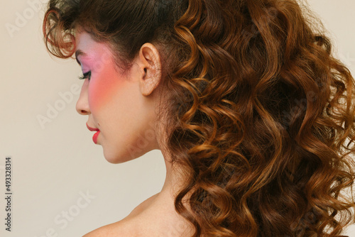 Woman with eighties make-up and long curly hair