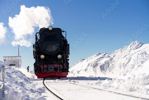 Historische Dampflokomotive im Schnee mit Dampf auf dem Brocken in Deutschland