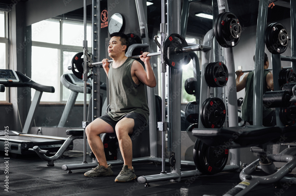Young man exercising in gym Young man exercising in gym
