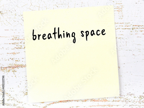Fotografía Yellow sticky note on wooden wall with handwritten word breathing space