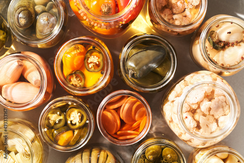 Opened jars with pickled vegetables photo