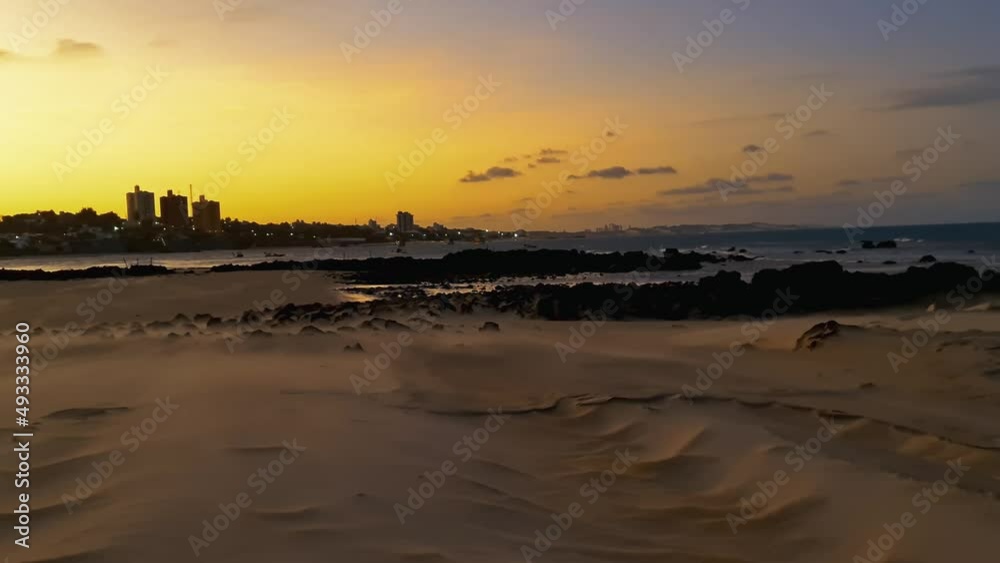 Vento na areia da praia no pôr do sol