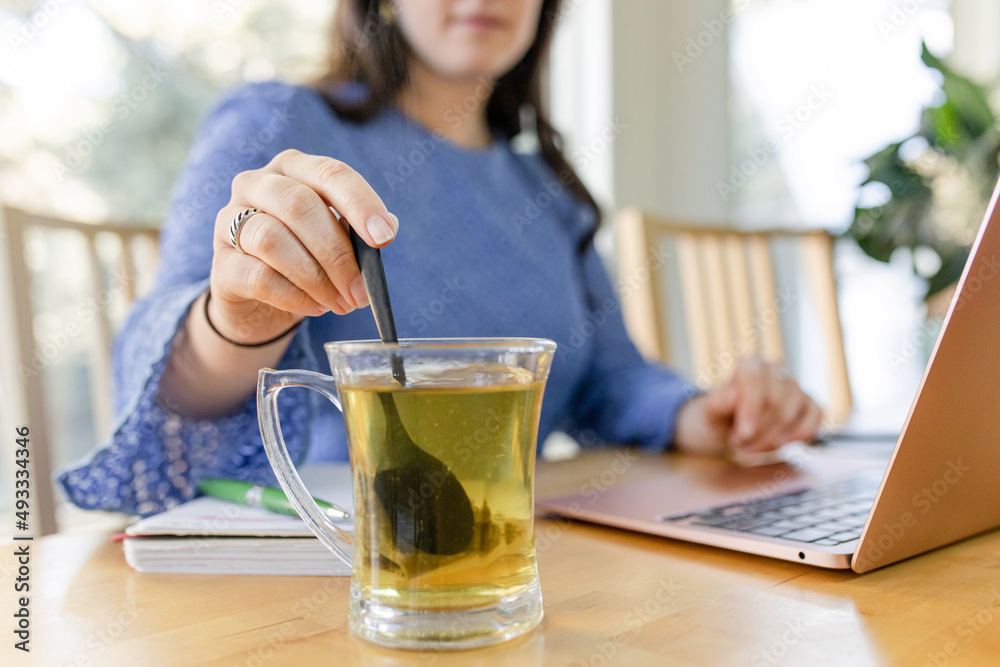 Female Stirring Tea While Working Female Stirring Tea While Working