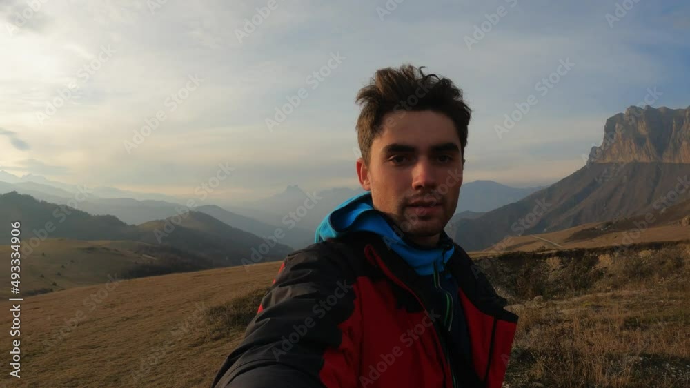the guy films himself against the background of mountains the guy films himself against the background of mountains