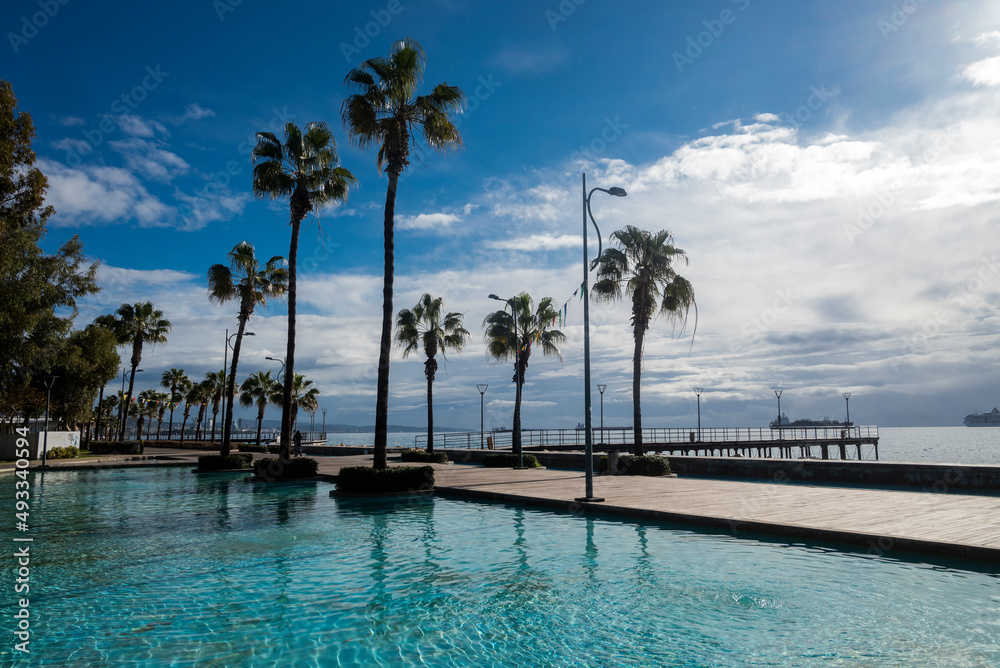 Obraz premium promenade Limassol beautiful with palm trees in cyprus with swimming pools in the parkon the seashore