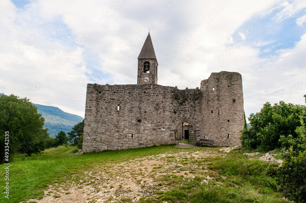 Old stone Church of the Holy Trinity with a tower, a historic building in Hrastovlje, Slovenia.