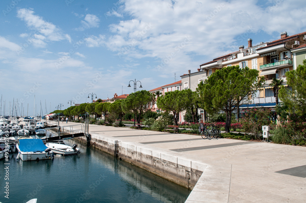 Naklejka premium Waterfront and harbor and boats in summer by the sea in Izola, Slovenia.