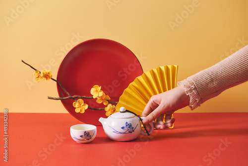 Hands of woman holding tea pot when celebrating Vietnamese New Year photo