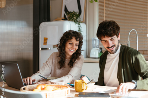 Couple paying bills online together at home photo