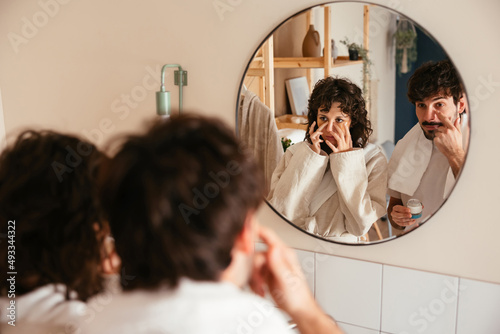 Couple doing daily beauty procedures in bathroom