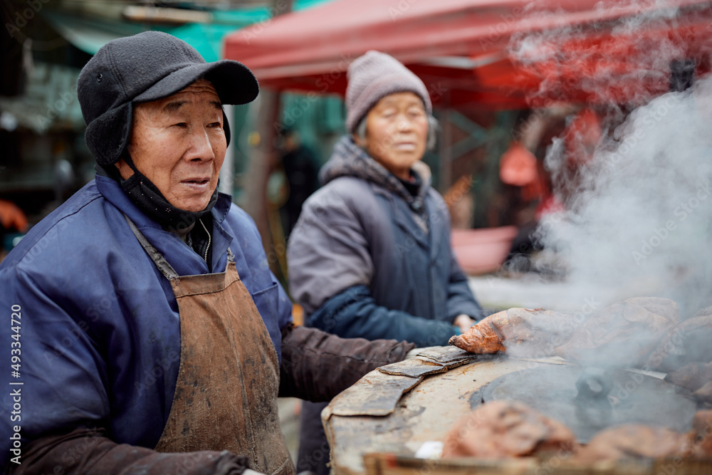 Older Chinese sweet potato vendors at a local market Older Chinese sweet potato vendors at a local market