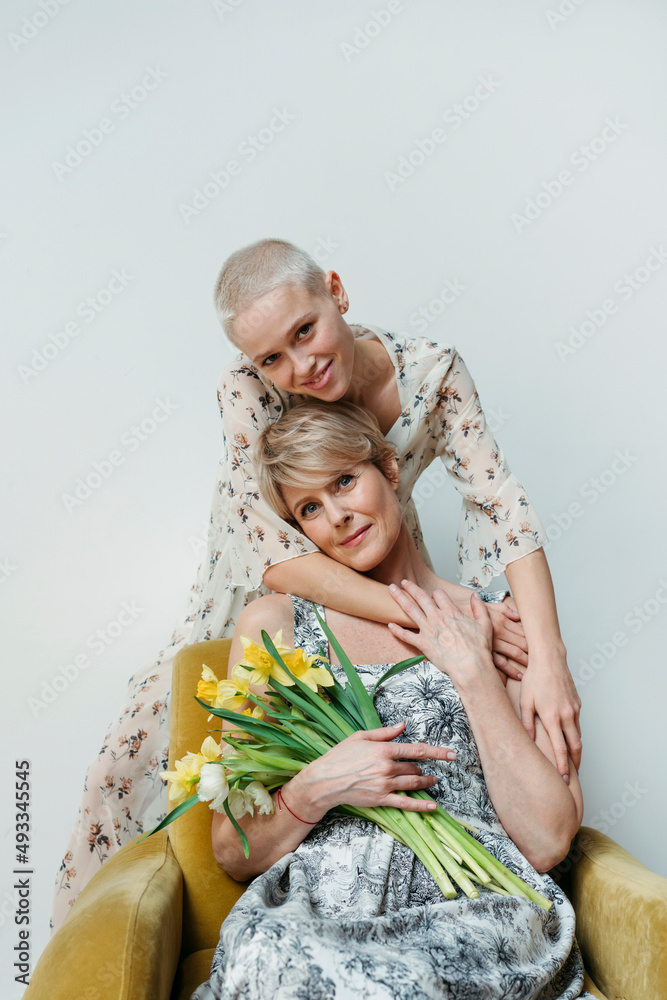 © Irina Polonina/Stocksy - Portrait of mother with flowers and daughter. © Irina Polonina/Stocksy - Portrait of mother with flowers and daughter.
