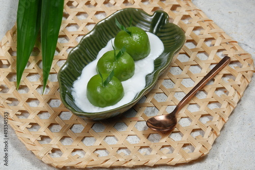 Kue Putri Mandi or badak berendam Are Steamed glutinous rice balls filled with coconut brown sugar paste and serve with coconut milk porridge. photo