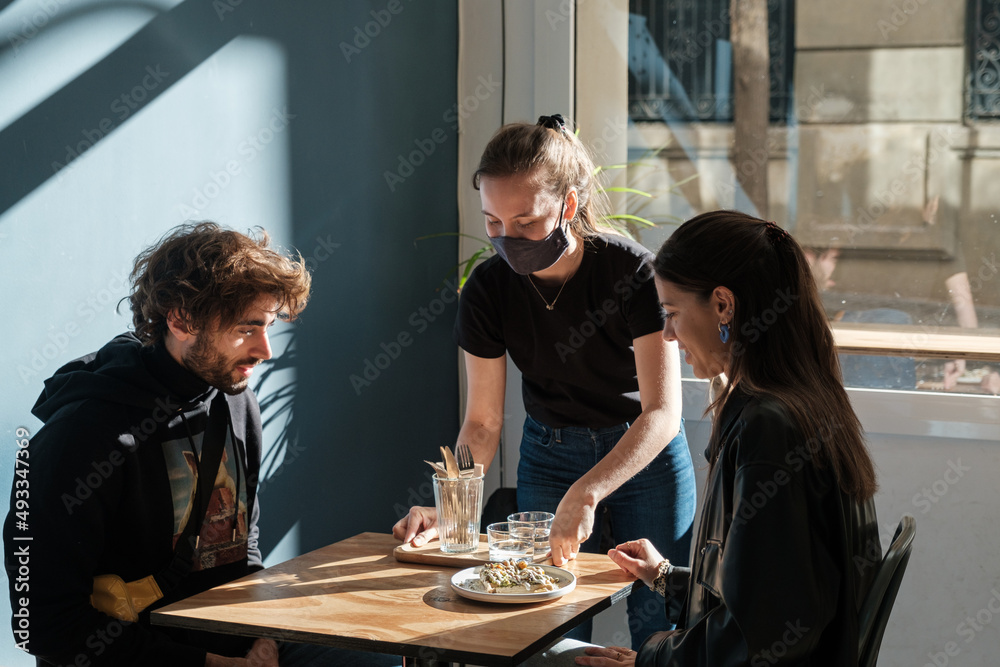 Waitress Serving food for Clients In Restaurant Waitress Serving food for Clients In Restaurant