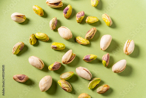 Pistachio nuts on green surface photo