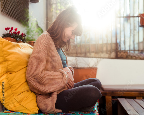 Happy pregnant woman feeling the baby