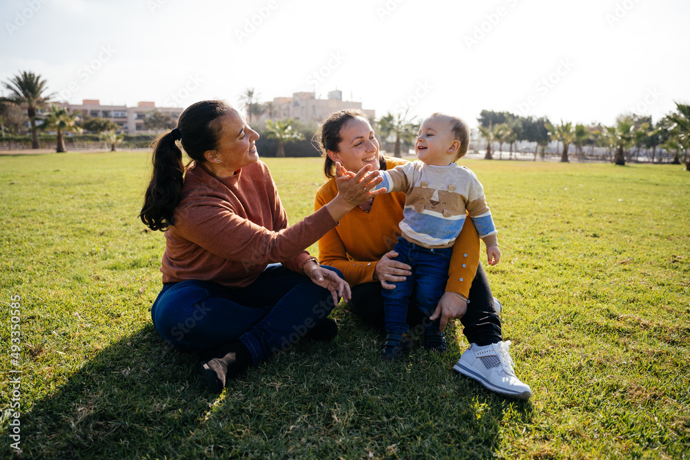 Boy with mother and aunt in park Boy with mother and aunt in park