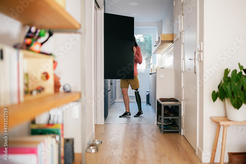 Person with a disability opening cabinet in kitchen photo