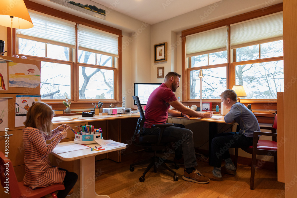 Dad Working in Home office helping kids with homework Dad Working in Home office helping kids with homework