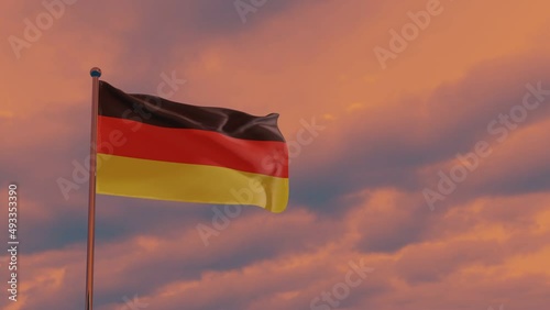 German flag in the wind against the backdrop of a dramatic sunset sky, German Unity Day