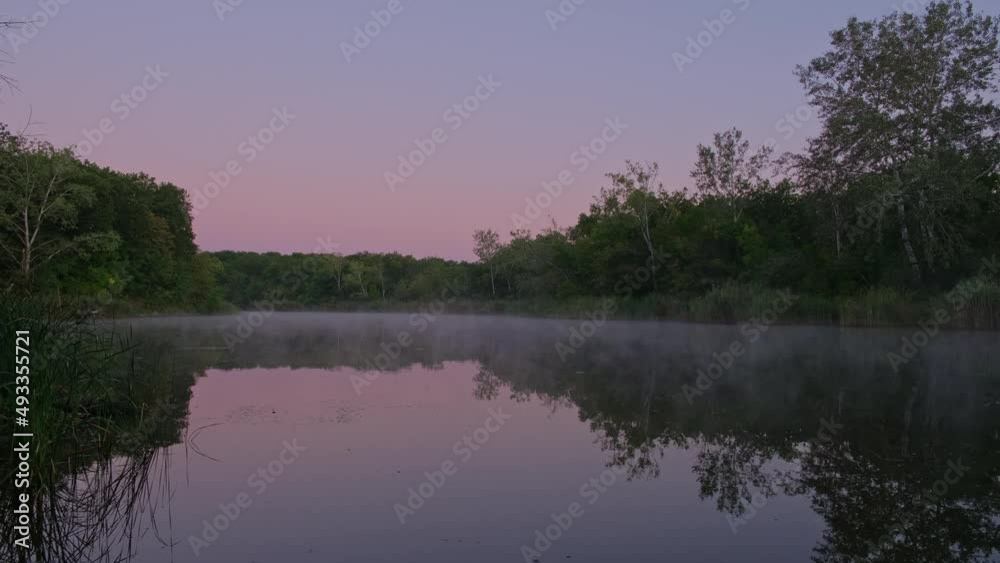 Fog above the river surface on a summer calm morning, trees reflected in the water. Silence and natural beauty. Nature. Landscape - Foggy river Fog above the river surface on a summer calm morning, trees reflected in the water. Silence and natural beauty. Nature. Landscape - Foggy river