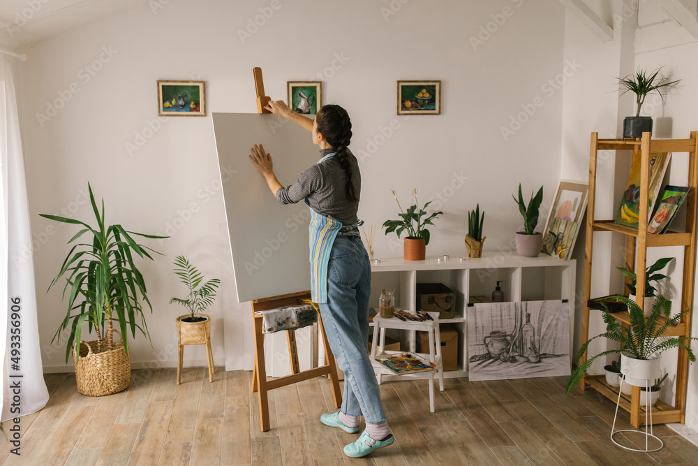 Artist preparing canvas for painting at home Artist preparing canvas for painting at home