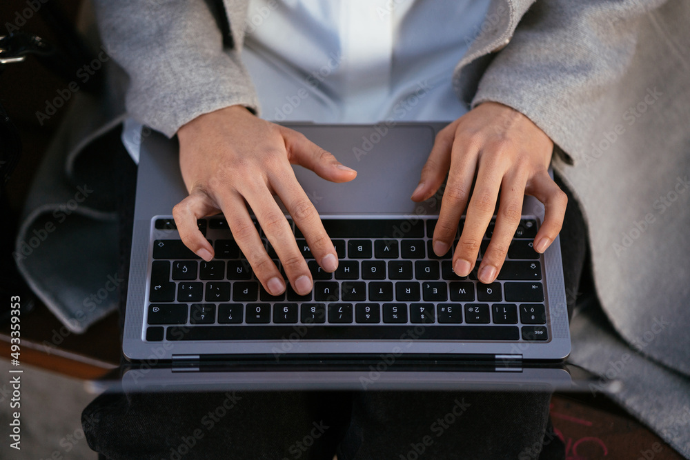Woman typing on laptop keyboard during remote work Woman typing on laptop keyboard during remote work