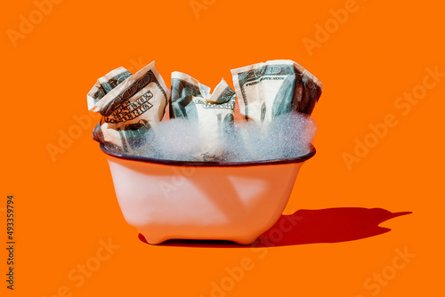 fake dollar bills soaking in a bathtub photo