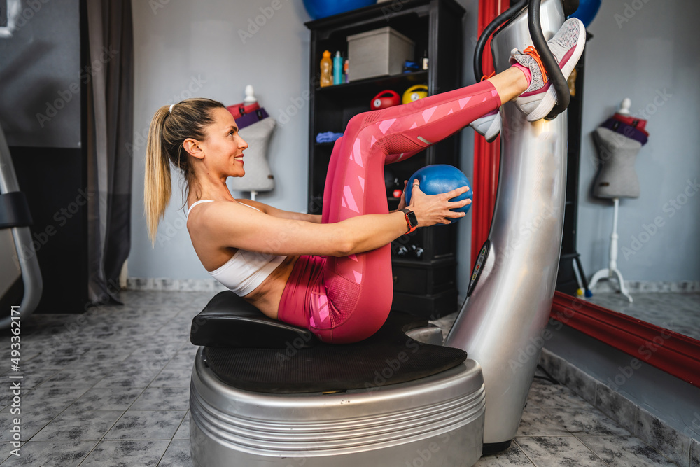 One woman training on the power plate machine female use powerplate for exercise abs workout side view copy space Stock Photo Adobe Stock