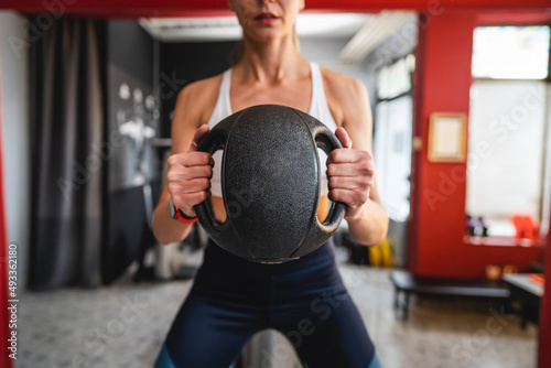 One woman training with medicine ball adult female exercise in front of mirror at gym copy space front view © Miljan Živković