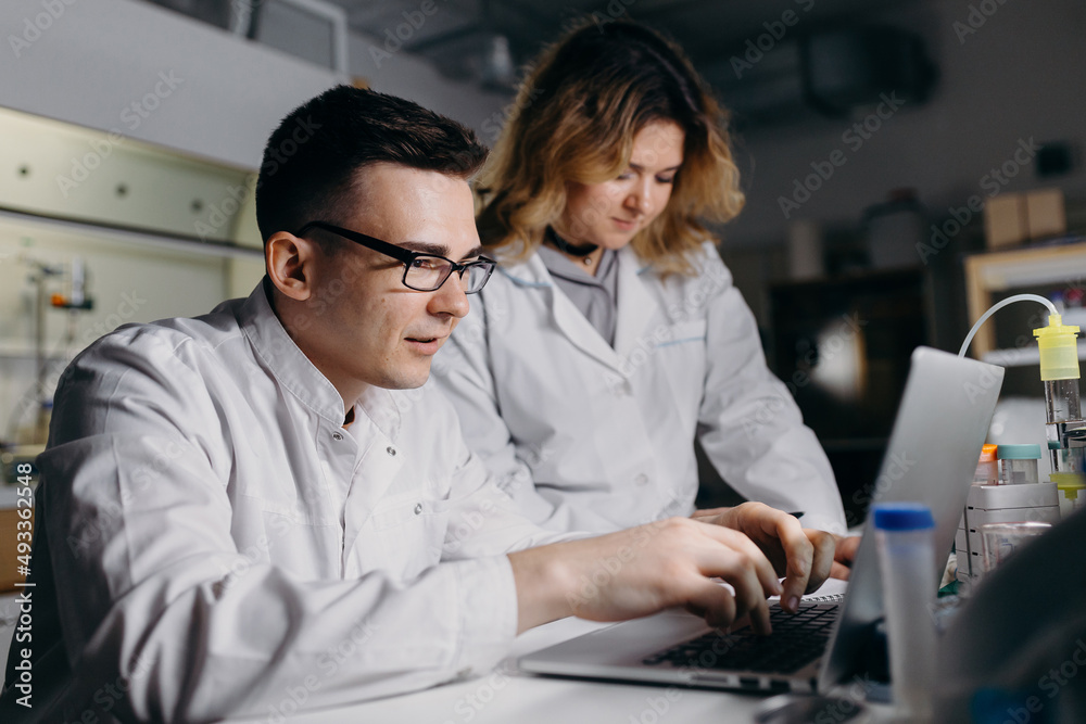 Scientist typing result of research on laptop Scientist typing result of research on laptop