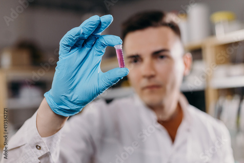 Serious scientist analyzing sample in test tube