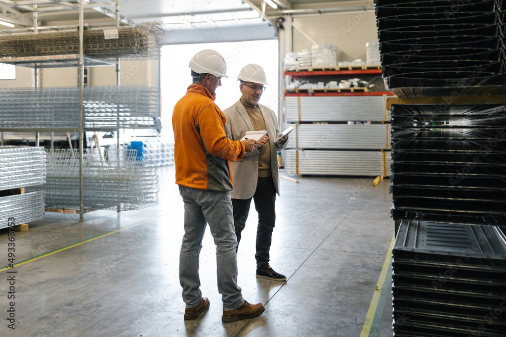 Two Male Colleagues Using A Tablet To Check Production Two Male Colleagues Using A Tablet To Check Production