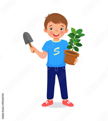 cute little boy holding potted plant and shovel in the garden